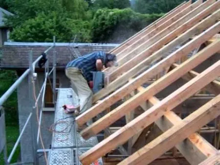 Montage d'une charpente de toiture à deux pentes avec ligne de bris