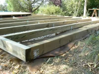 Structure de terrasse avec des solives en sapin traité aux sels. 